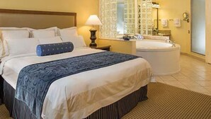 A hotel room with a large bed, a separate sitting area, a bathtub, and a bathroom with a large mirror and glass partition. - Fantastic condo in Orlando; fully equipped kitchen, washer/dryer, WiFi (Orlando)