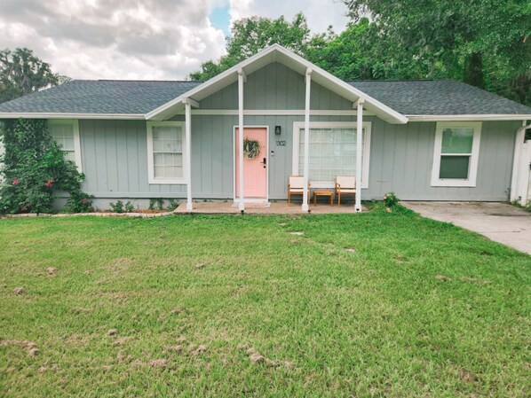 A single-story house with a front porch, a mailbox, and a door with the number 1302.