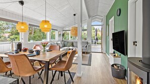 Un comedor acogedor con una mesa de madera, sillas de cuero y lámparas amarillas colgantes.