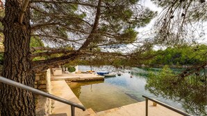 A waterfront area with a dock, boats, and a stone staircase leading down to the water. - 1 bedroom beautiful apartment in Krusevo (Krusevo)