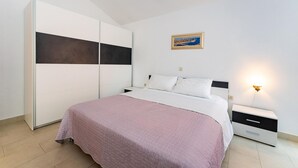 A bedroom with a bed, a nightstand, a wardrobe, and a painting on the wall. - 1 bedroom beautiful apartment in Krusevo (Krusevo)