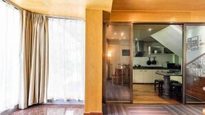 A modern kitchen with a dining area, sliding glass doors leading to a balcony, and a wooden floor. - Xiamen Yuqiao Villa (International Convention and Exhibition Center Huandao Road Branch) (Xiamen)