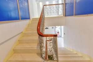 Una escalera con barandilla de madera y balaustradas de metal decorativas.