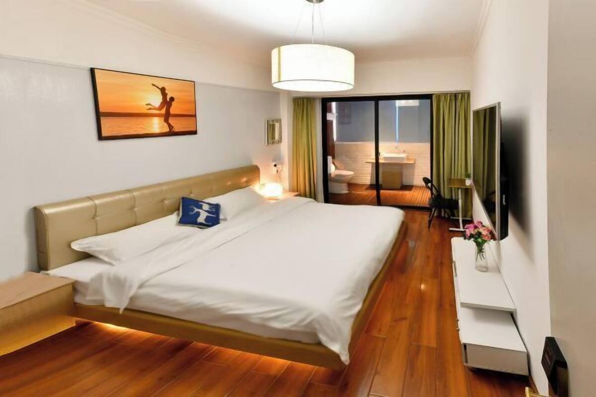 Une chambre d’hôtel avec un lit, une télévision, un bureau et une vue sur l’extérieur.