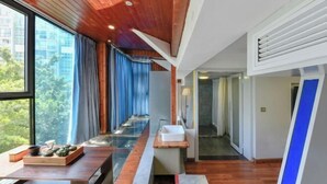 A modern interior with a wooden ceiling, a long hallway, a sink, and a view of greenery outside. - Xiamen Yuqiao Villa (International Convention and Exhibition Center Huandao Road Branch) (Xiamen)