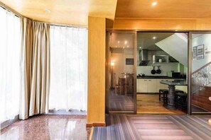 Un interior moderno con zona de cocina, puertas corredizas y una escalera.