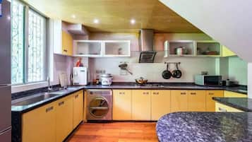 Una cocina compacta con armarios de madera, horno integrado y lavadora.