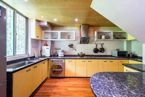 Una cocina compacta con armarios de madera, horno integrado y lavadora.