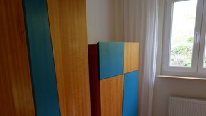 A room with a large wardrobe, a white carpet, and a window with curtains. - Quiet vacation apartment in the southern Black Forest, 10 minutes from St. Blasien (Dachsberg (Südschwarzwald))