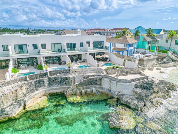 Un complexe hôtelier doté d’une piscine, d’un espace extérieur aménagé et offrant une vue sur l’océan.