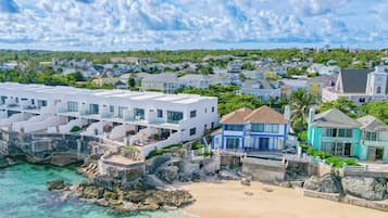 A coastal residential area with modern houses, a beach, and clear turquoise waters.