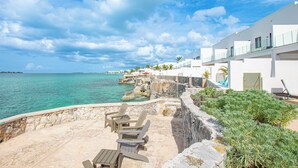 A coastal hotel with a stone patio, outdoor seating, and a view of the sea. - 3 BR Oceanfront Beach House with Private Pool Gated Community Staircase to Ocean (Nassau)