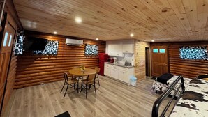Ein rustikales Blockhaus mit Essbereich, Küche und Schlafzimmer.