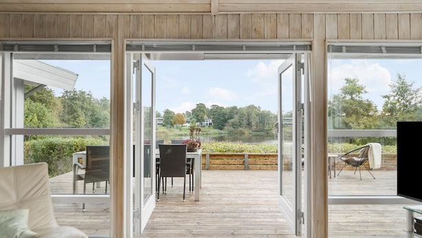 Et moderne interiør med store skydedøre, der fører ud til en terrassedæk.
