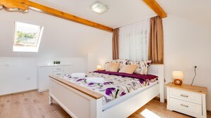 A bedroom with a bed, bedside tables, a window, and a small desk.