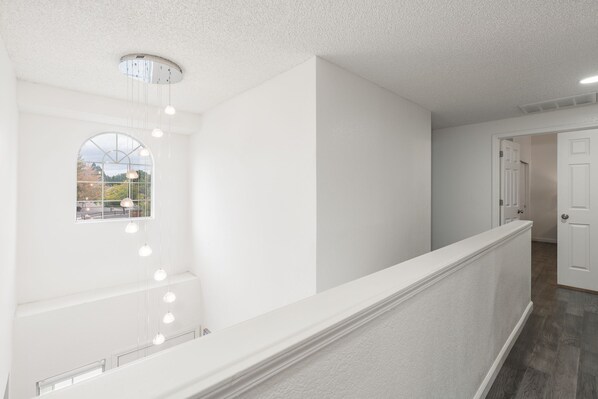 A spacious hallway with a high ceiling, a large arched window, and a modern light fixture. - New! Modern 4BR walk to Reno-Sparks Conv Center, Atlantis Casino & shops (Reno)