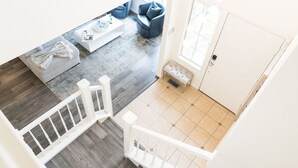 Ein modernes Wohnzimmer mit einem grauen Sofa, einem weißen Couchtisch und einem blauen Sessel.