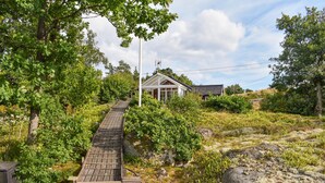 A wooden staircase leading to a house with a white roof and a glass conservatory. - Nice home in Ronneby with WiFi (Ronneby)