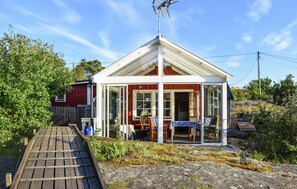 A small, single-story building with a sloped roof and a glass front. There is a wooden deck leading to the entrance. - Nice home in Ronneby with WiFi (Ronneby)