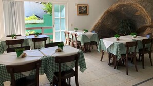 A restaurant with checkered tablecloths, wooden chairs, and potted plants. - Pousada Anambé (Angra dos Reis)