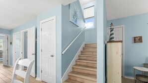 A hallway with light blue walls, white doors, and a wooden staircase. - 2 Bikes~ Newly renovated Pool~Bike to Seaside (Santa Rosa Beach)
