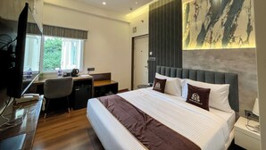 A hotel room with a bed, desk, chair, and a television. - Wishotel Inn Rasa Royal - A Boutique Hotel (Indore)