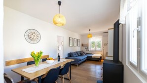 A modern living room with a wooden dining table, blue sofa, and a black cabinet. - 2 bedroom beautiful home in Starigrad (Starigrad)