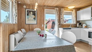 Une cuisine moderne avec des meubles blancs, un lave-vaisselle intégré et une machine à café.