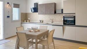 Eine moderne Küche mit Essbereich, ausgestattet mit Backofen, Mikrowelle und einem großen Fenster.