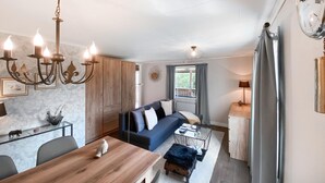 A cozy living room with a sofa, a wooden dining table, and a chandelier. - Nice home in Sävsjö with WiFi (Sävsjö)