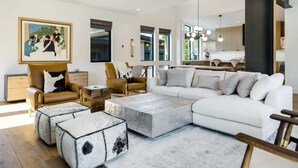 Una sala moderna con un sofá modular, sillones de cuero y una mesa de centro.