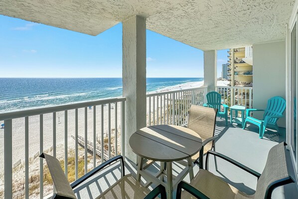 A balcony with a view of the beach and ocean.
