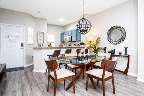 A modern kitchen with blue cabinets, a central island, and a hanging light fixture.