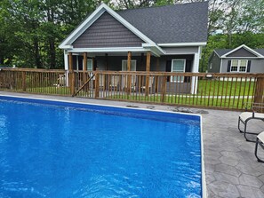 A residential swimming pool with a wooden deck and a house in the background. - The Monarch - Private Setting, Heated Pool, 6 Bedroom, New Build. 6 min to CDP (Fly Creek)