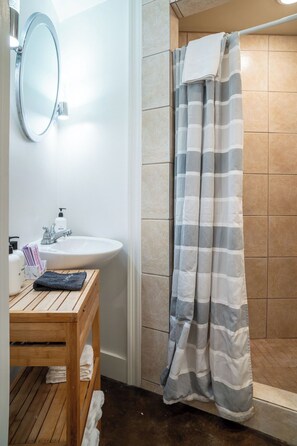 Un baño con lavabo, espejo y cortina de ducha.
