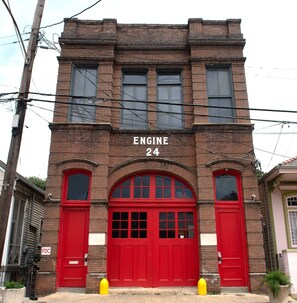 A brick building with a red firehouse number 24 sign. - Engine 24 Firehouse Courtyard Room 5 (New Orleans)