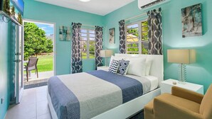Un dormitorio con cama, una silla, una mesita de noche y una ventana con cortinas.