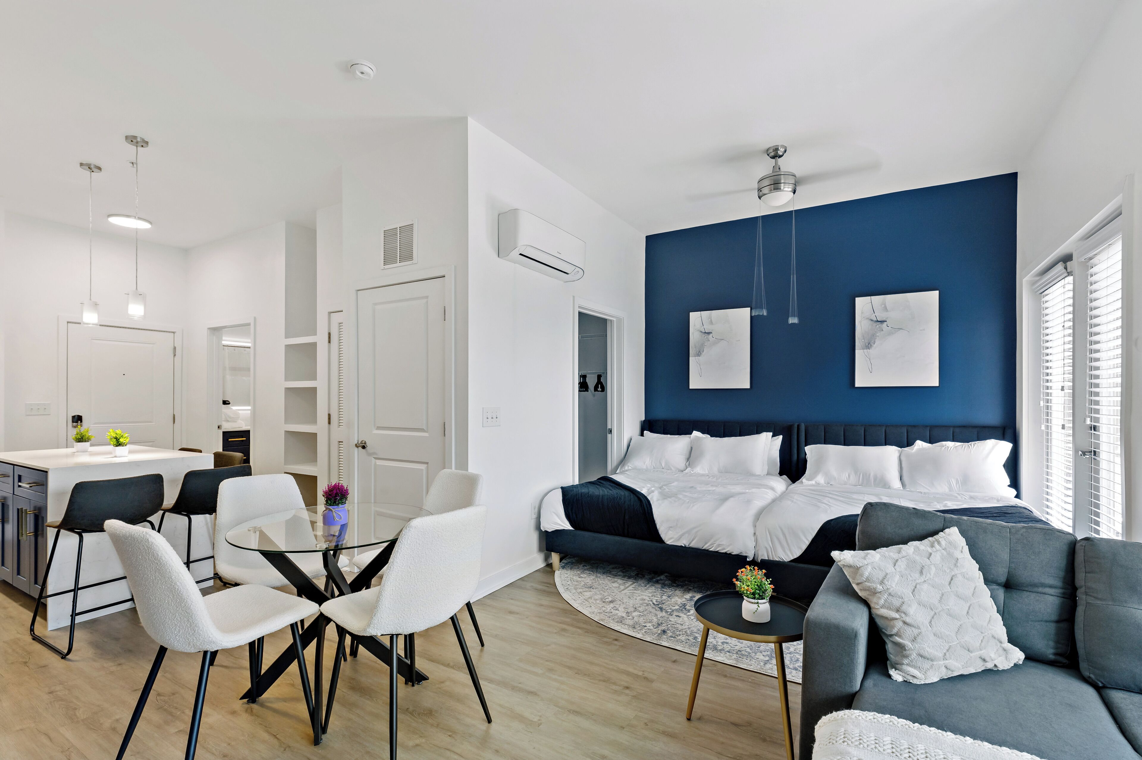 Une chambre d’hôtel moderne dotée d’un grand lit, d’un canapé, d’un coin repas avec des chaises et d’une cuisine.