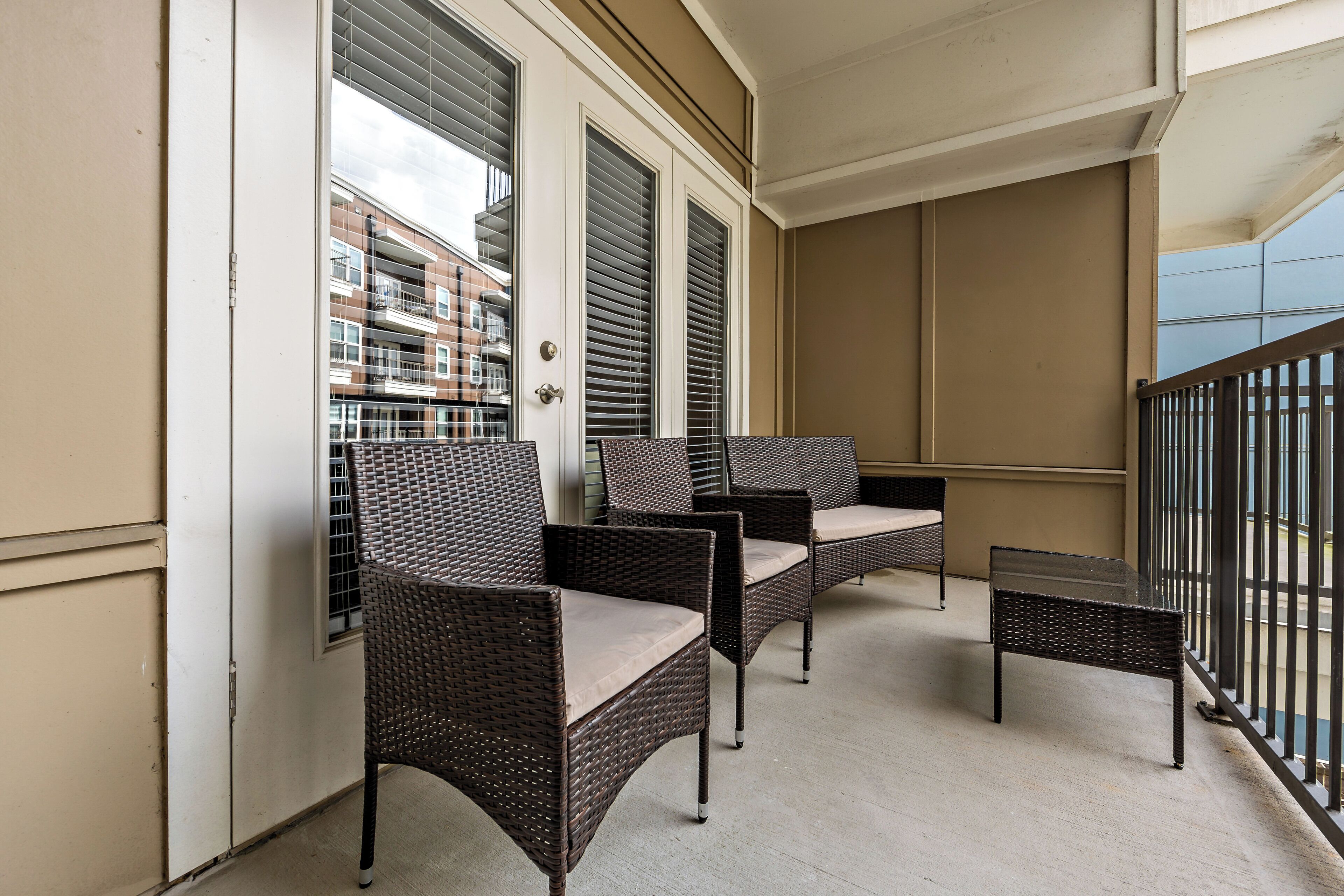Ein Balkon mit Korbmöbeln und Blick auf Gebäude.