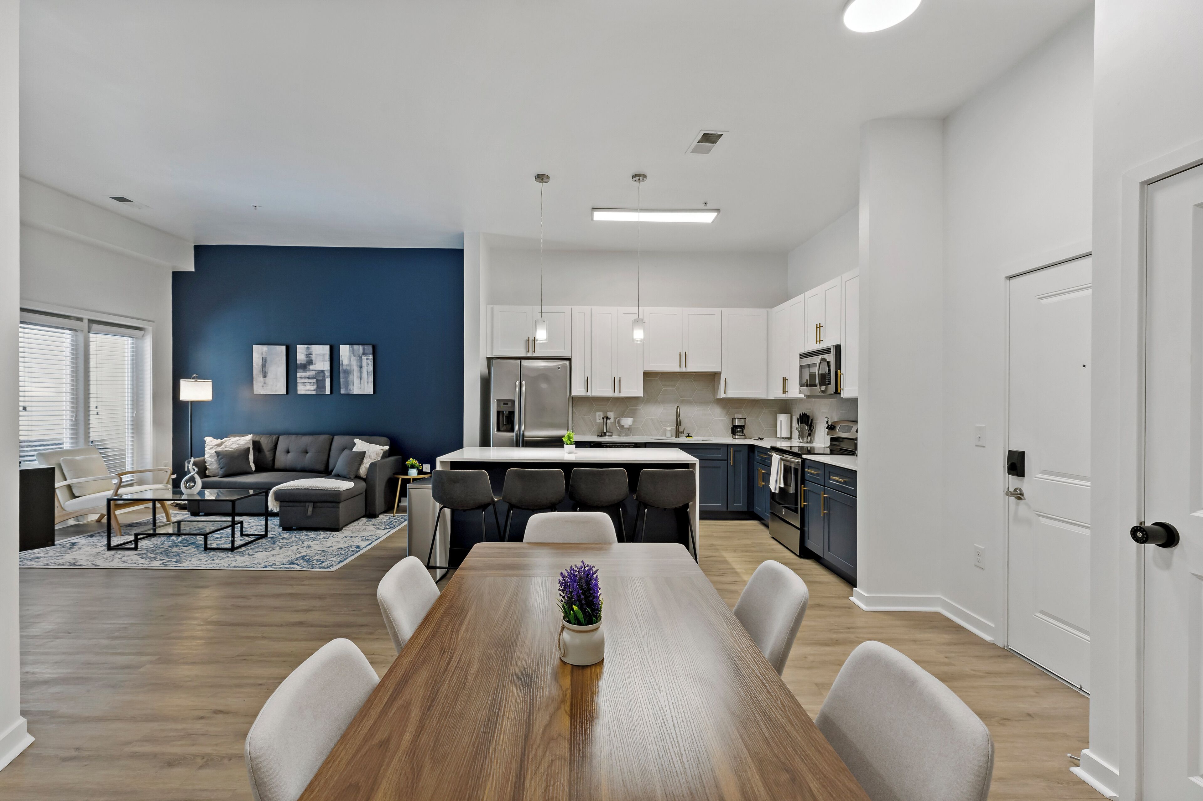 A modern apartment with a dining area, kitchen, and living room.