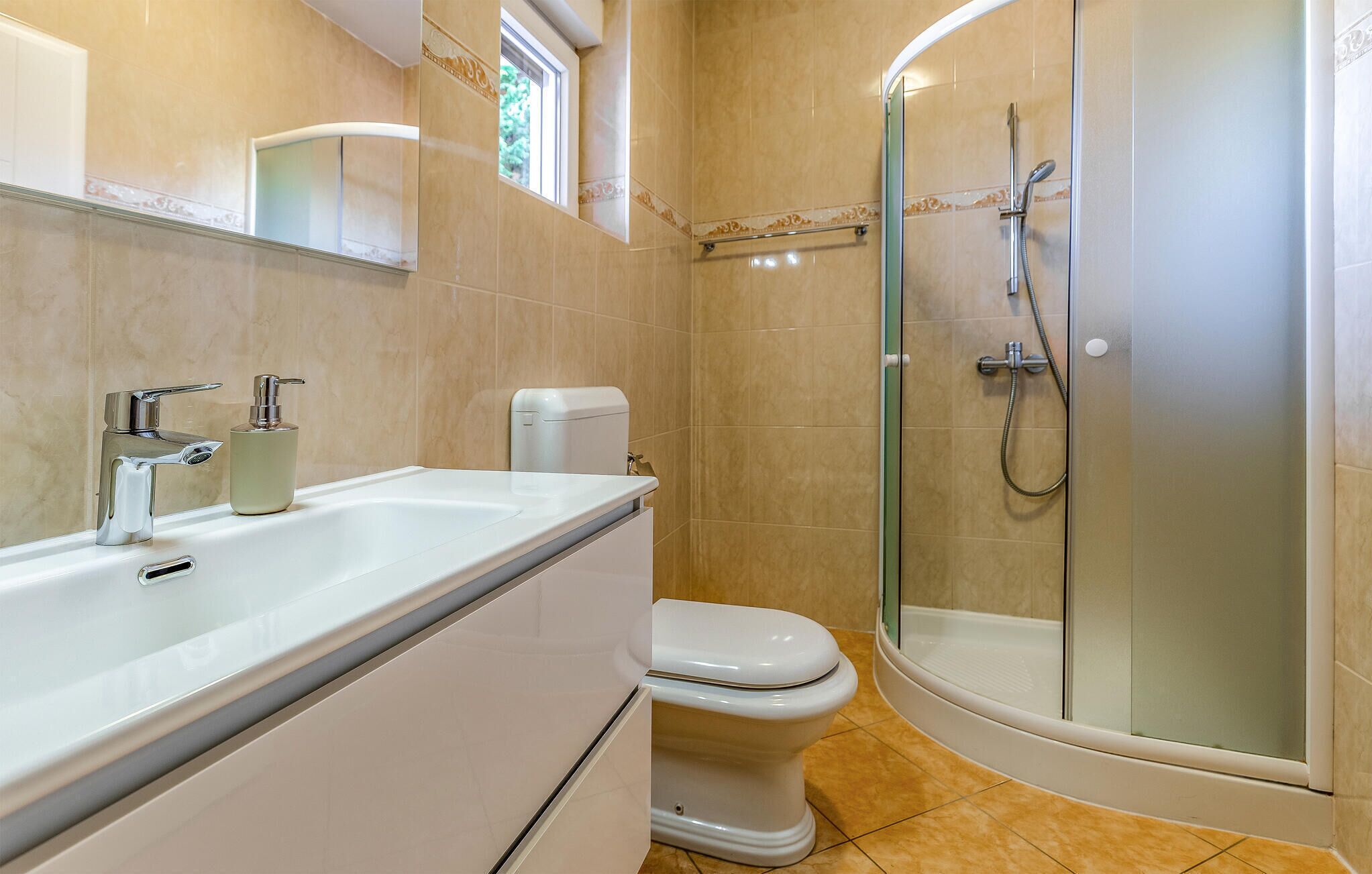 Une salle de bain moderne avec une douche à parois de verre, un lavabo blanc et des toilettes.