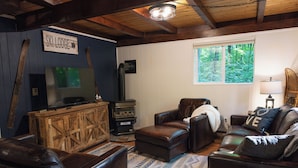Una sala de estar acogedora con mobiliario de cuero oscuro, un aparador de madera y un letrero que dice "SKILODGE".