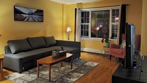 A living room with a sofa, coffee table, and TV. - Full 4 bedrooms single house at Halifax Peninsula (Halifax)