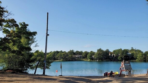 A lakeside area with a sandy beach, a lifeguard stand, and a row of trees. - Full 4 bedrooms single house at Halifax Peninsula (Halifax)