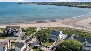 Eine Wohngegend an der Küste mit Häusern, einem Strand und Blick aufs Meer.