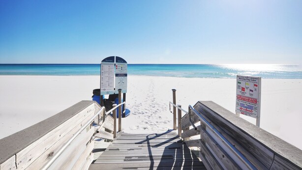 A wooden boardwalk leading to a beach with clear skies and calm waters. - Waters Edge 304 • Luxury 3BR 3BA, Balcony, Large Pool, Covered Parking, Free Bch Service (Fort Walton Beach)
