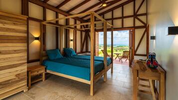 Een slaapkamer met een hemelbed, houten wanden en uitzicht op het landschap.