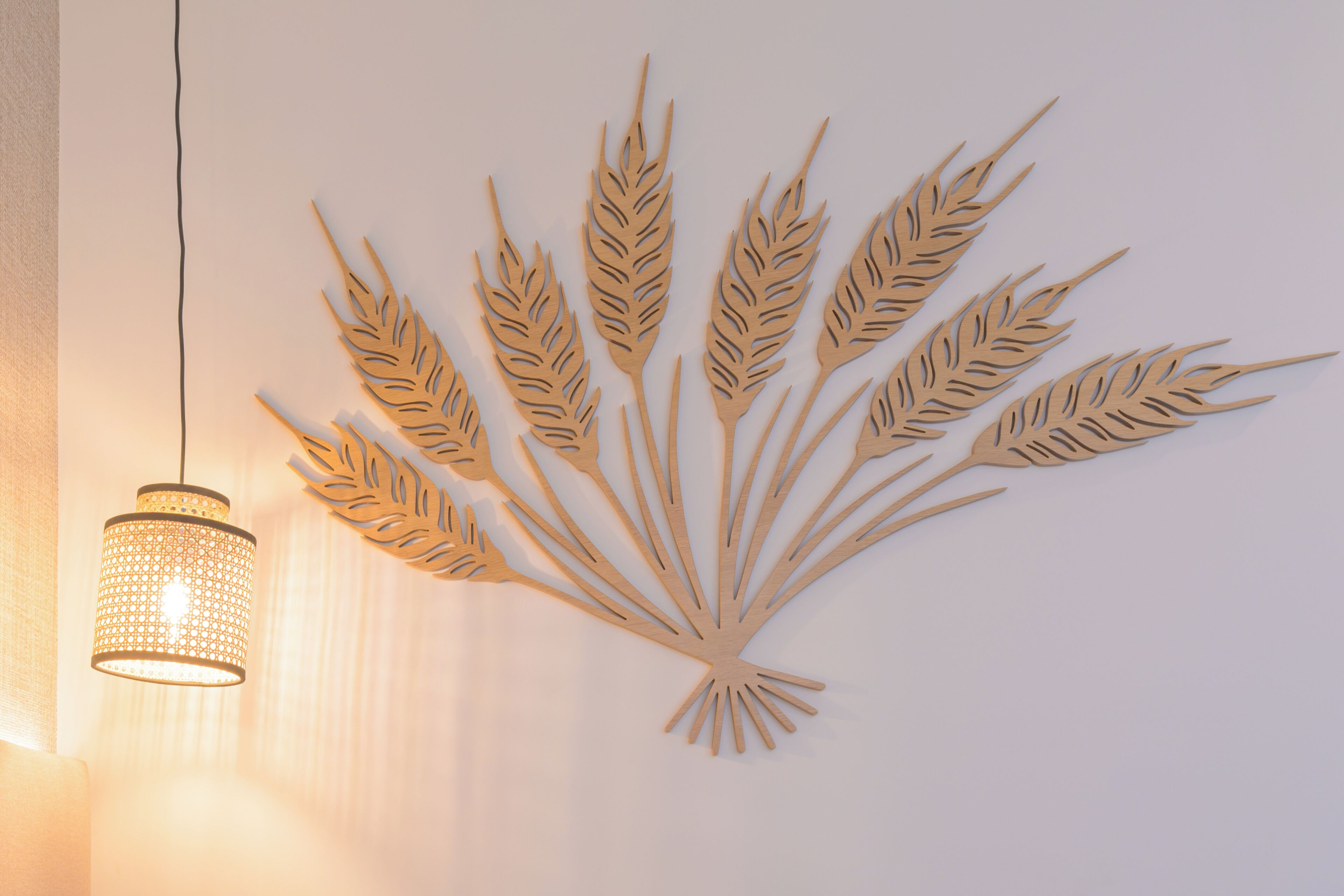 Eine Wanddekoration aus Holz mit Weizenähren und eine hängende Leuchte.