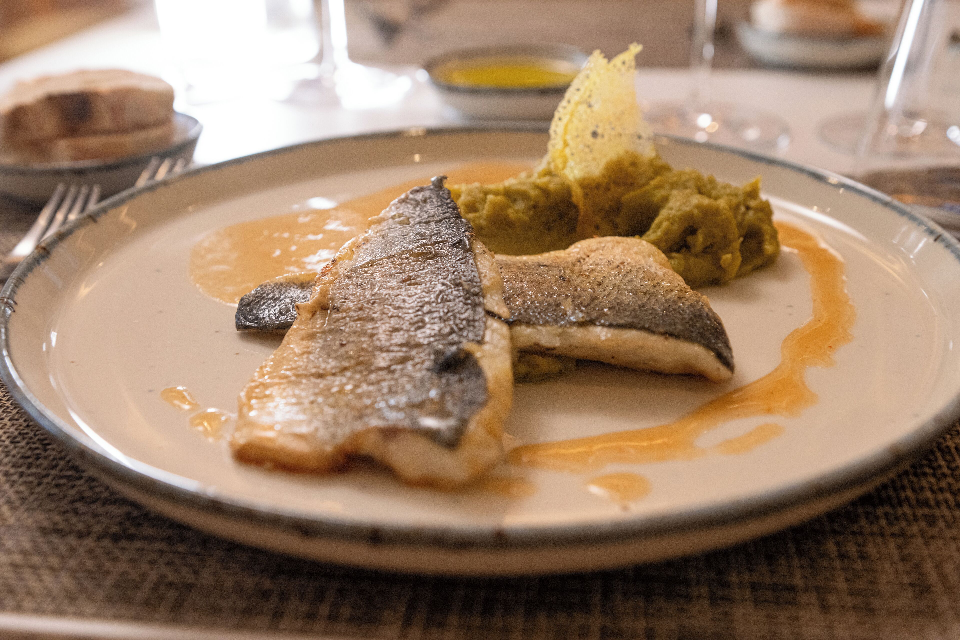 Un plato de comida con pescado y puré de papas.