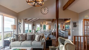 A spacious living area with a large sofa, a dining table, and a kitchen in the background. - Beech Mountain Retreat with Spectacular Panoramic Views (Banner Elk)